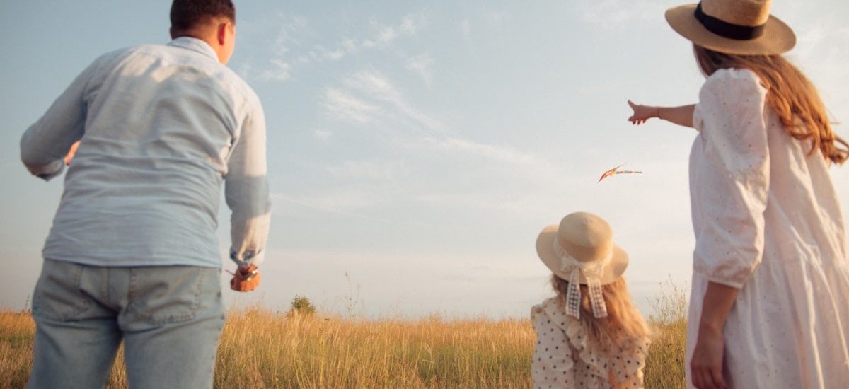 man in white dress shirt and woman in brown dress standing on green grass field during