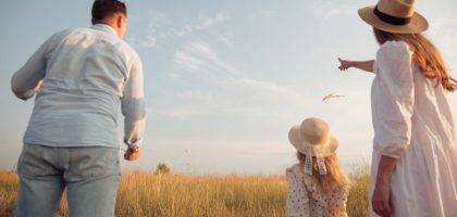 man in white dress shirt and woman in brown dress standing on green grass field during