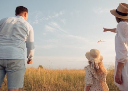 man in white dress shirt and woman in brown dress standing on green grass field during